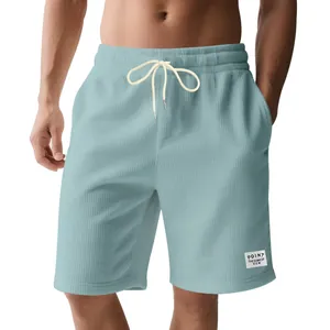 Close-up of light blue corduroy men's shorts with white drawstring and logo detail.