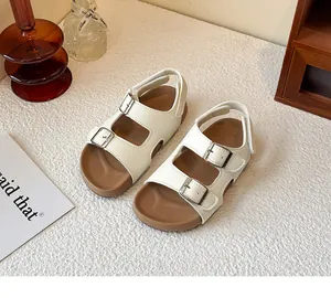 Vista lifestyle di sandali bianchi per bambini con fibbie argentate regolabili