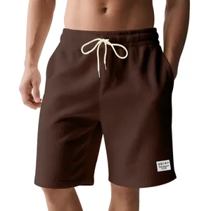 Detailed view of men's brown corduroy sports shorts featuring a drawstring waist and logo