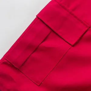 Close-up of red cargo shorts pocket with high-quality stitching and fabric texture.