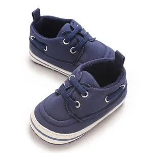 Detail view of navy blue canvas baby walking shoes featuring soft soles and white trim