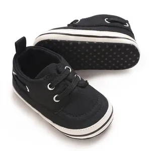 Close-up of soft-soled black baby shoes showing anti-slip dotted bottom