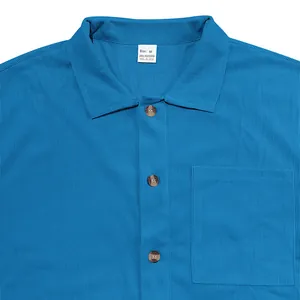 Close-up detail of light blue corduroy men's shirt showing collar buttons and pocket