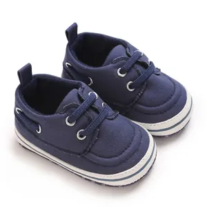 Detailed macro view of navy blue baby canvas walking shoes featuring soft white soles