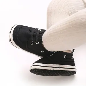 Close-up of black soft-sole baby pre-walker shoes with elegant white stitching detail.