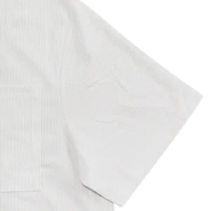 Macro view showing the fine corduroy texture and stitching of light gray short-sleeve shirt