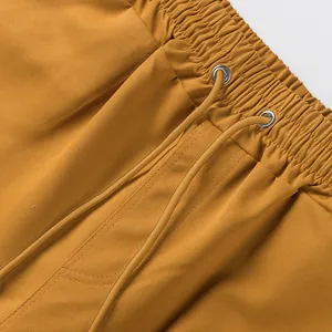 Detail of mustard yellow cargo shorts showing elastic waistband and drawstring texture