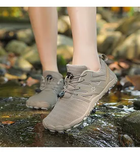 Detail view of breathable outdoor water shoes being worn in a natural stream setting