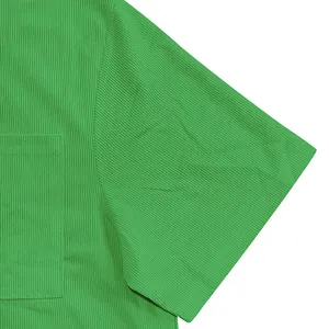 Detailed close-up showing the green corduroy fabric texture and pocket stitching.