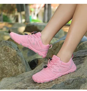Close-up of pink breathable outdoor running shoes with non-slip sole on rocky ground