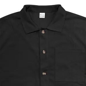 Close-up detail showing the corduroy texture and button collar of a black men's casual shirt