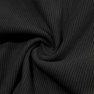 Macro view of black corduroy fabric texture showing detailed vertical ribbing patterns