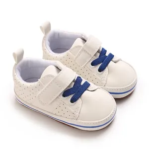 Close-up of white infant walker shoes with blue laces and soft non-slip soles