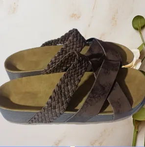 Detailopname van damesplatformsandalen met gekruiste bandjes en gevlochten details