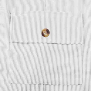 Close-up detail of pocket and button on men's white corduroy cargo shorts