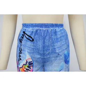 Detail of blue denim-print wide-leg pants with colorful butterfly patterns