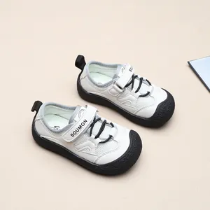 Detailansicht von oben auf weiß-schwarze Kindersandalen mit schützender Zehenkappe