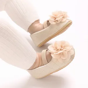 Gros plan détaillé de chaussures Mary Jane beige pour bébé avec fleur en tissu.