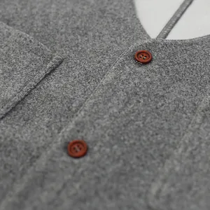 Primer plano de la textura de la tela del chaleco de lana gris y botones marrones
