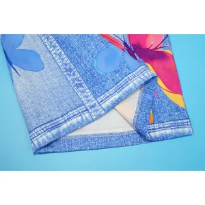 Detail of overlock stitched hem on blue denim print trousers with butterfly pattern