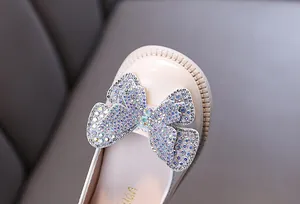 Close-up of girl's princess flat shoe with sparkling rhinestone butterfly bow detail