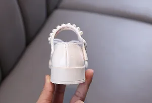 Detailed back view of white patent leather girl's princess shoes with pearl trim