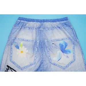 Macro view of blue butterfly and white flower prints on denim-patterned casual wide-leg pants