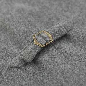 Primer plano de la hebilla de metal bronce ajustable en la correa del chaleco de lana
