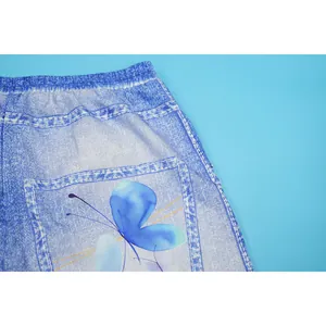 Detail of casual wide-leg pants featuring a vibrant blue butterfly print on denim texture.