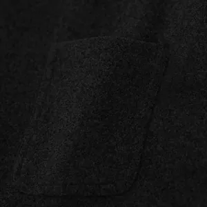 Vista macro detallada del tejido de lana texturizado y el bolsillo de un chaleco de hombre