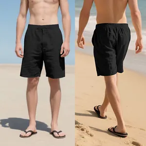 Front and back macro view of men's loose black linen drawstring shorts for beach life
