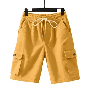 Detailed macro view of yellow corduroy cargo shorts with drawstring and button pockets.