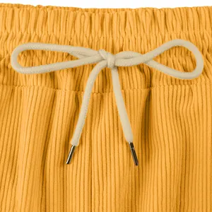 Detailed close-up of mens yellow corduroy shorts featuring cream drawstring and texture