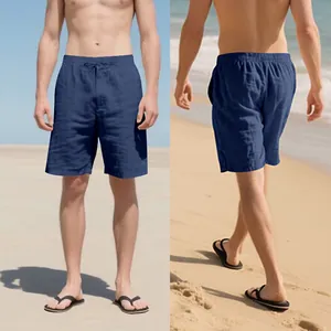 Men's navy blue linen shorts with drawstring waist and pockets on beach background