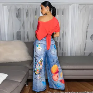 Close-up of women's wide leg pants with colorful butterfly and floral print details