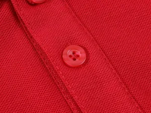 Macro view of breathable red pique polo shirt fabric and its matching tonal button