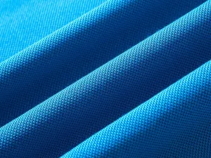 Primo piano macro dettagliato del tessuto in cotone piqué blu traspirante con trama a maglia