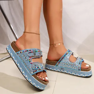 Detailed close-up of blue platform sandals featuring colorful beads and rhinestone buckles