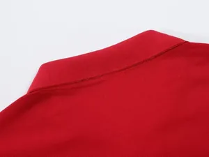 Close-up of red polo shirt collar showing breathable piqué fabric texture.