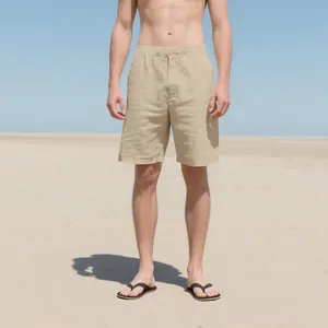 Detailed visual of men's beige linen casual shorts presented in a natural beach setting