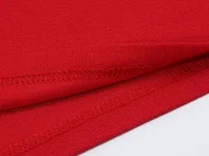 Macro view showing the high-quality hem stitching and breathable fabric of a red polo shirt