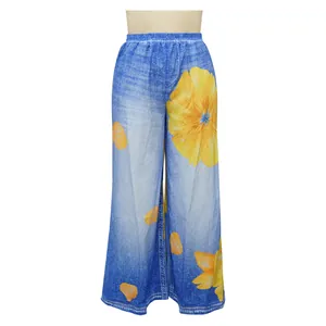 Close-up detail of large yellow floral print on blue denim-style wide-leg casual pants