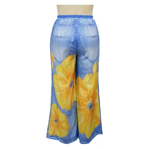 Detail of wide-leg trousers featuring yellow floral print and faux denim texture.