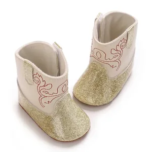 Dettaglio di stivaletti alla moda per bambina con glitter dorati e ricami rossi.
