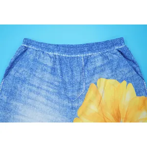 Close-up of elastic waistband on blue wide-leg pants with yellow floral print.