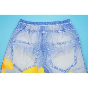 Detail of denim print wide-leg pants showing elastic waist and sunflower pattern