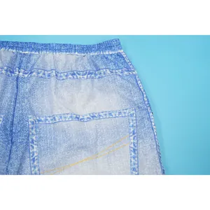Detailed macro view of the realistic denim print texture and elastic waist on blue trousers