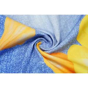 Macro shot of blue denim texture fabric featuring large yellow floral print design
