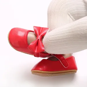 Close-up detail of red baby princess shoes with a bow and soft sole for toddler walking