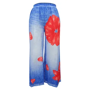 Detailed view of women's wide-leg pants showing the vibrant red floral and blue denim print